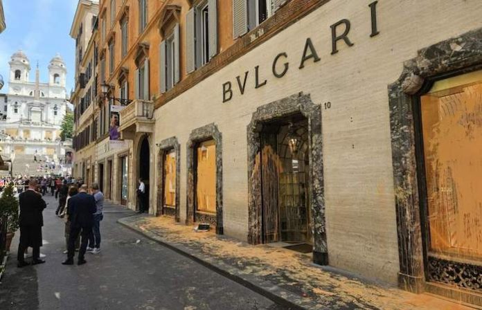 Ecologistas italianos vierten pintura naranja contra escaparates de marcas famosas